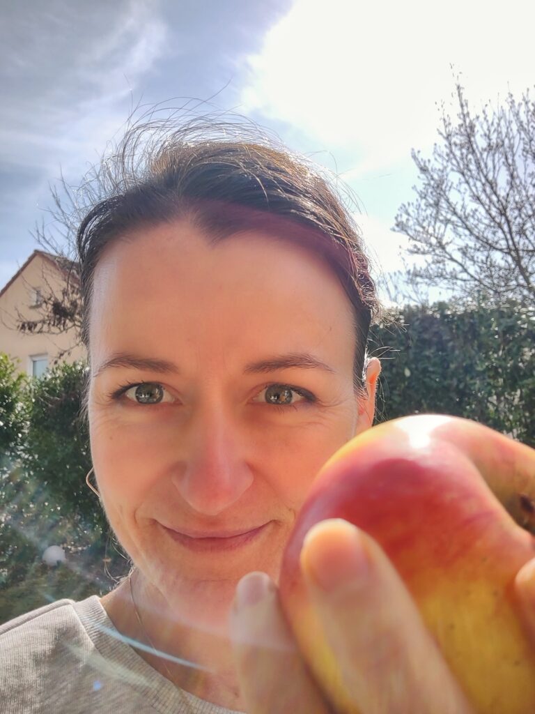 Lächelnde Frau mit Apfel in der Hand