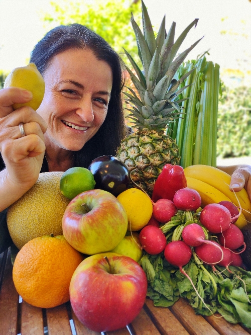 Frau mit einem Berg an Obst und Gemüse im Arm