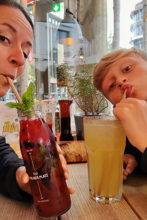 Frau mit Junge beim Limonade trinken mit dem Strohhalm