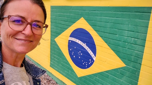 Frau vor einer Wand mit Brasilianischer Flagge