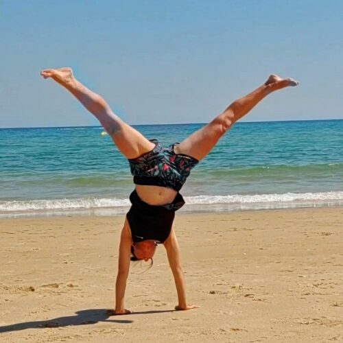 Frau beim Radschlagen am Strand